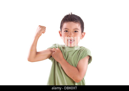 A young boy shows us his arm muscle in this studio setting. Stock Photo
