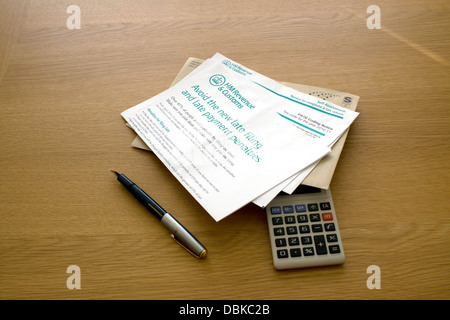 HMRC Letter about late filing of tax return on a table with envelope, pen and calculator Stock Photo