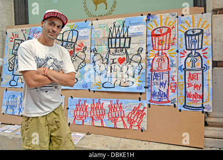 Portrait of a New York City graffiti artist in front of his work for sale in Soho, downtown New York City. Stock Photo
