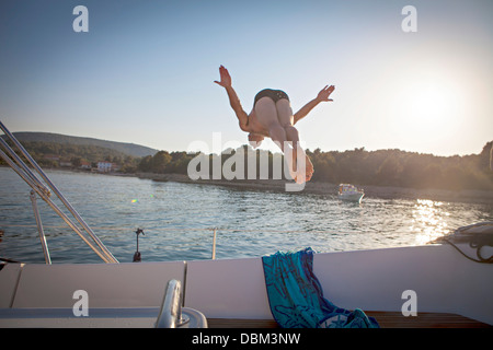 Croatia, Adriatic Sea, Young man diving into water, rear view Stock Photo