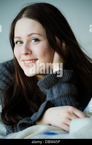 Long brown hair woman lying naked in white bed, shallow DOF Stock Photo