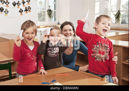 Children In Nursery School Holding Paper Planes, Kottgeisering, Bavaria, Germany, Europe Stock Photo