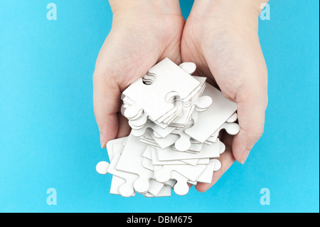 Hand holding piles of jigsaw puzzle pieces Stock Photo