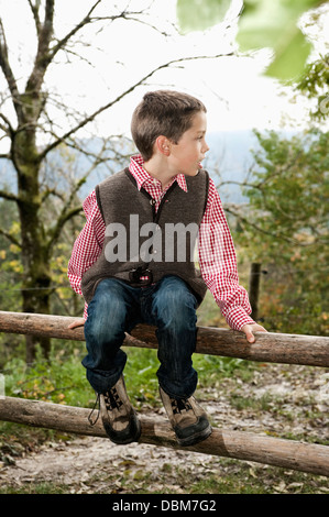 Boy Sitting On Wooden Fence, Bavaria, Germany, Europe Stock Photo