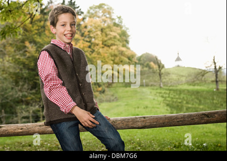 Boy Sitting On Wooden Fence, Bavaria, Germany, Europe Stock Photo