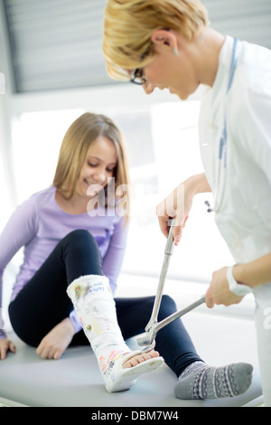 Female doctor cutting plaster cast of girl, Osijek, Croatia Stock Photo