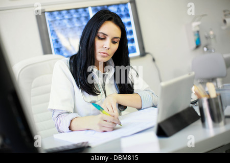 Female doctor sitting at desk, doing paperwork, Osijek, Croatia Stock Photo