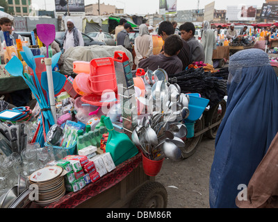 veiled woman looking at household products, bazaar, Kabul, Afghanistan Stock Photo