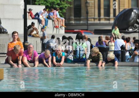 Trafalgar Square, London, UK. 1st August 2013. Children cool their hands in the fountains of Trafalgar Square in the hot weather. Credit:  Matthew Chattle/Alamy Live News Stock Photo