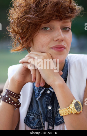 Fashionable teenage hipster girl with lip ring piercing and spiked trendy accessories posing. This is how teenagers look like today! Stock Photo