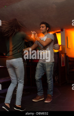 Young Asian couple dancing salsa in a colourful bar Stock Photo
