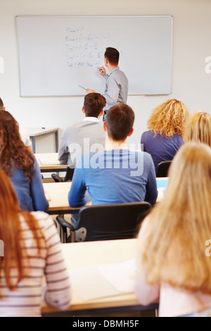 Teacher writing financial mathematics formulas on whiteboard in university Stock Photo