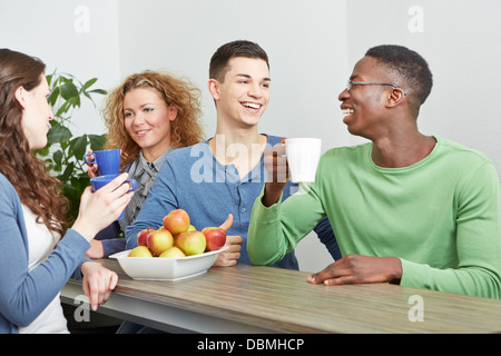 Many smiling colleagues drinking coffee in break room Stock Photo