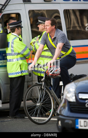 British Prime Minister, David Cameron makes his way around London on a bicycle. Stock Photo