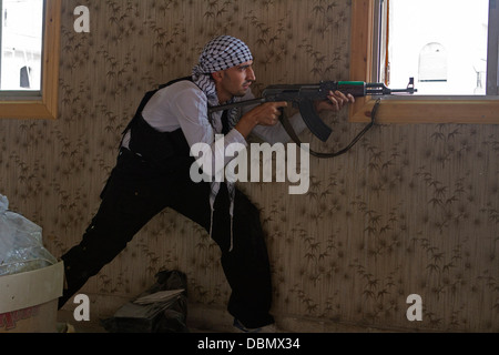 Aleppo, Syria: A Free Syrian Army member takes aim at a regime position in Karm AL Jabal. Stock Photo