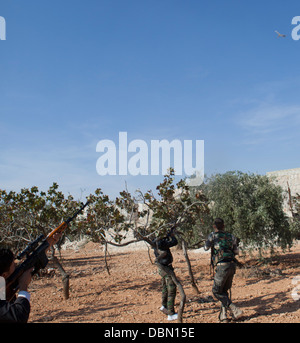 Free Syrian army members shoot at an aircraft near the Aleppo International Airport during the Eid Al Adah holiday. Stock Photo