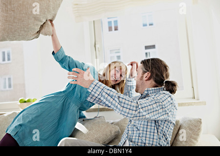 A Couple Pillow Fights In Their Living Room Stock Photo