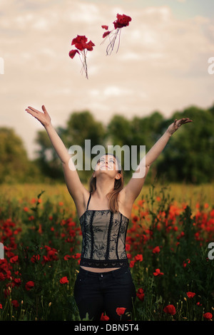 Young woman playing with poppies in a poppy field, Croatia, Europe Stock Photo