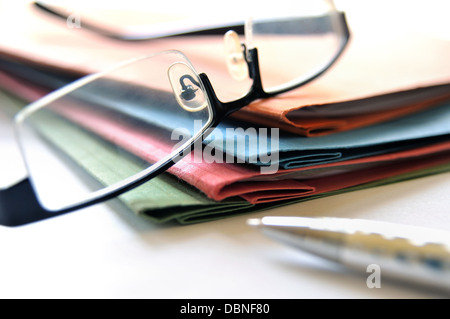 Group of multicolored office folders and glasses Stock Photo
