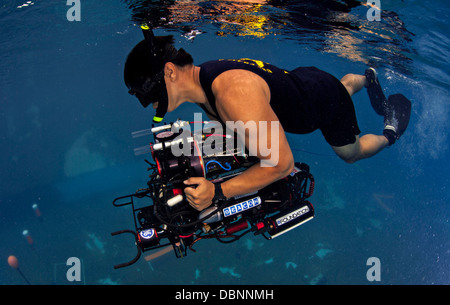 A US Navy Diver recovers an autonomous underwater vehicle built by students from Cornell University after navigating through an obstacle course at the Transducer Evaluation Center's Anechoic Pool at Space and Naval Warfare Systems Center Pacific July 23, 2013 in San Diego, CA. The goal of the annual RoboSub competition is to advance the development of autonomous underwater vehicles. Stock Photo