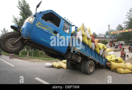 TIPPY TOE TRUCK REACHES TIPPING POINT     A lorry load o' trouble became a truckin' disaster for a driver, who took his farmer's delivery service to unprecedented heights and, promptly, got the sack.....tons of 'em! The overloaded vehicle, travelling on t Stock Photo