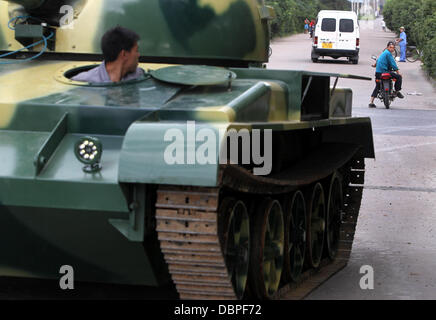 HOMEMADE TANK TAKES TO THE STREETS Residents of Hangzhou, China, may have had cause for alarm when they stepped outside to see a T60 tank rolling through the streets but the 10 ton vehicle was in fact a homemade full-scale replica of the killing machine. The tank took a team of a dozen workers seven months to make and at 6.24m x 3.27m can reach a top speed of 15 mph. The owner plan Stock Photo