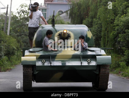 HOMEMADE TANK TAKES TO THE STREETS Residents of Hangzhou, China, may have had cause for alarm when they stepped outside to see a T60 tank rolling through the streets but the 10 ton vehicle was in fact a homemade full-scale replica of the killing machine. The tank took a team of a dozen workers seven months to make and at 6.24m x 3.27m can reach a top speed of 15 mph. The owner plan Stock Photo