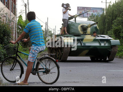 HOMEMADE TANK TAKES TO THE STREETS Residents of Hangzhou, China, may have had cause for alarm when they stepped outside to see a T60 tank rolling through the streets but the 10 ton vehicle was in fact a homemade full-scale replica of the killing machine. The tank took a team of a dozen workers seven months to make and at 6.24m x 3.27m can reach a top speed of 15 mph. The owner plan Stock Photo