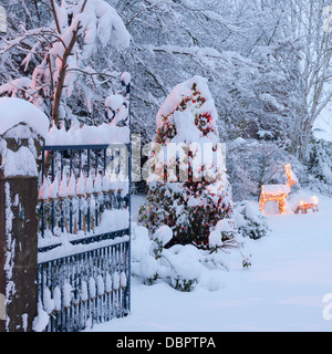 A fresh falling of snow covers the Christmas decorations in the garden of a large, gated country property. Stock Photo