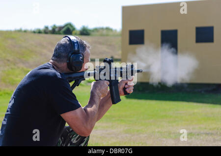 Ballykinlar, Northern Ireland. 2nd August 2013 - A man fires a Colt M4A1 at a training range Credit:  Stephen Barnes/Alamy Live News Stock Photo