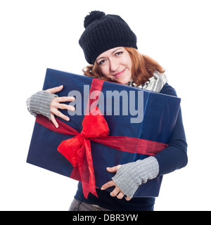 Satisfied happy winter woman holding big present, isolated on white background. Stock Photo