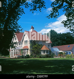 Large lawn in front of Victorian country house with conservatory Stock Photo
