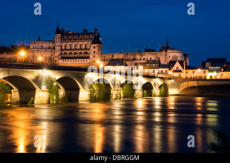 The historic Château, town & bridge at Amboise illuminated in the evening and reflected in the river Loire, France Stock Photo