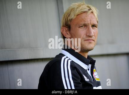 Lippstadt, Germany. 03rd Aug, 2013. Leverkusen's head coach Sami Hyypia sits before the first round DFB Cup match between SV Lippstadt 08 and Bayer Leverkusen at the Stadium Am Waldschloesschen in Lippstadt, Germany, 03 August 2013. Photo: JONAS GUETTLER Stock Photo