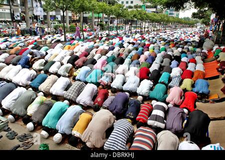 Dhaka, Bangladesh. August 2, 2013 - Muslim devotees offer the prayer of Jummah-tul-Wida (Last Friday of Ramadan) on the street in front of a mosque in Dhaka. The month of Ramadan is a sacred period of fasting and prayer for all Muslims. During Ramadan the Muslims from all over the world seek forgiveness for past sins and pray for future guidance. Stock Photo