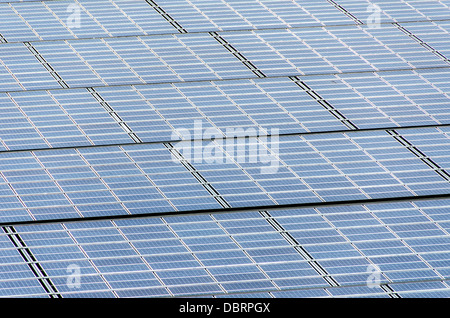 An array of solar photovoltaic panels used for converting sunlight into electrical energy in bright sunlight. Stock Photo