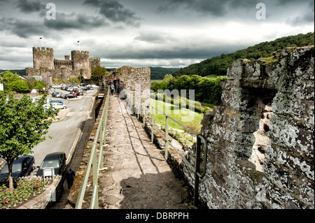 CONWY, Wales — The imposing ramparts of Conwy Castle, a 13th-century medieval fortress in North Wales, United Kingdom. Built by King Edward I during his conquest of Wales, these massive stone walls and fortifications showcase the advanced military architecture of the period. The well-preserved ramparts offer visitors a glimpse into medieval defensive strategies and provide panoramic views of the surrounding landscape. Stock Photo