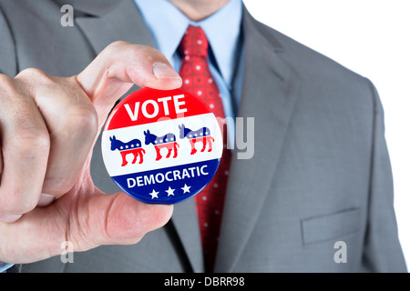 A man holds up a democratic vote badge lapel pin Stock Photo