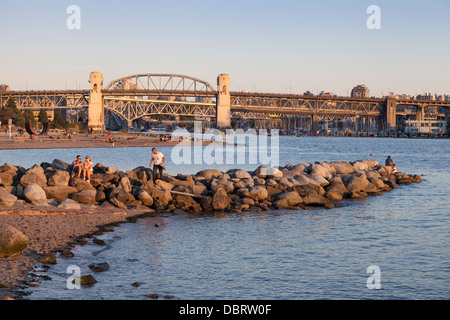 Couple resting on a jetty in Sunset Beach Park - West End, Vancouver, British Columbia, Canada Stock Photo