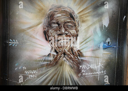 London 3 August 2013.  Portrait of 'Madiba' see on a doorway on Brick Lane in East London by street artist Paul Donsmith.  Credit David Mbiyu/Alamy Live News Stock Photo