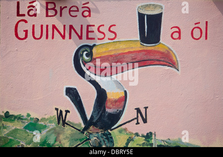 Painted Guinness mural wall art with toucan balancing pint on beak on wall of pub Sign signage in Gaelic County Galway Ireland Stock Photo