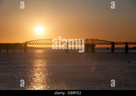 Barmouth Bridge Sunset view through girders harbour in background Gwynedd Mid Wales UK Stock Photo