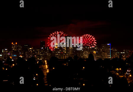 VANCOUVER, CANADA, 3rd August, 2013.  Fireworks light the skies beyond downtown Vancouver at the third installment of the Honda Celebration of Light fireworks competition.  This evening's show featured Thailand's entry into the annual competition.  The popular event attracts thousands of spectators to English Bay in Vancouver. Credit: Maria Janicki/Alamy Live News