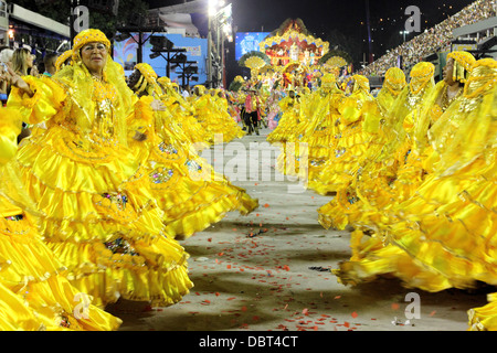 A troupe of dancers in yellow dresses in the Sambadrome for Carnival in Rio de Janeiro, Brazil on Monday, 11 February 2013. Stock Photo