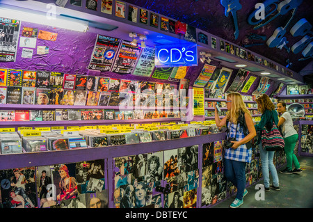 Teenage girls in a vintage record store, with guitars on the ceiling, in Camden Market, London, England, UK. Stock Photo