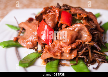 fried beef, green peppers and beans on a white plate Stock Photo