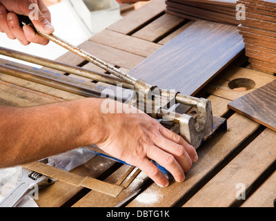 Manual ceramic cutting machine being used by a man Stock Photo