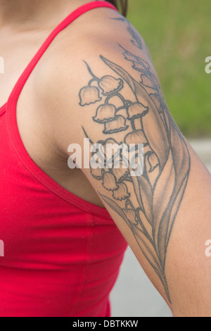 Lily of the Valley tattoo on woman's arm Stock Photo