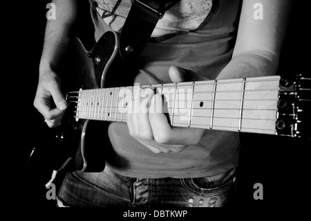 Man playing guitar. Selective focus on his left hand on guitar Stock Photo