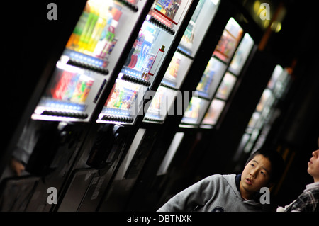 A boy in Japan looking at vending machines selling drinks. Stock Photo